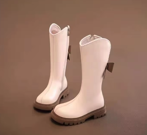 Eleganckie kozaki dla dziewczynki z kokardą i perełkami to modne buty zimowe z wysoką cholewką wykonaną ze skóry ekologicznej, które gwarantują ciepło i wygodę noszenia dzięki praktycznemu zamkowi.