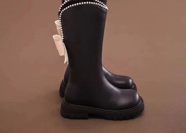 Eleganckie kozaki dla dziewczynki z kokardą i perełkami to modne buty zimowe z wysoką cholewką wykonaną ze skóry ekologicznej, które gwarantują ciepło i wygodę noszenia dzięki praktycznemu zamkowi.