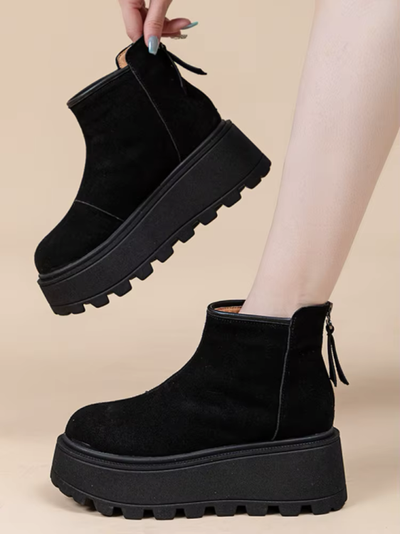 Zbliżenie na modne buty zimowe na grubej podeszwie typu traktor w kolorze brązowym i czarnym.