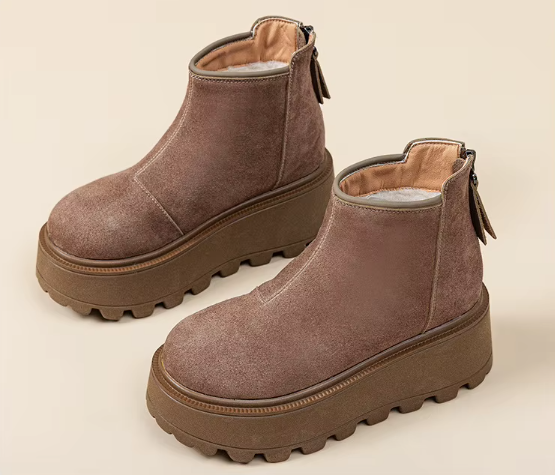 Zbliżenie na modne buty zimowe na grubej podeszwie typu traktor w kolorze brązowym i czarnym.