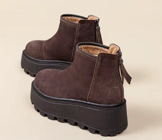 Zbliżenie na modne buty zimowe na grubej podeszwie typu traktor w kolorze brązowym i czarnym.